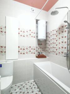 baño blanco con bañera y aseo en Manufactura luxery apartments en Sumy