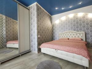 1 dormitorio con cama y espejo en Manufactura luxery apartments en Sumy