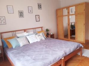 a bedroom with a large bed with pillows at Rozmaring Apartman Zánka in Zánka