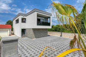 ein Haus mit einem großen Fenster auf einer Terrasse in der Unterkunft Apartments Laguna in Nin