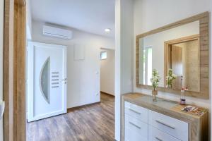 ein Badezimmer mit Spiegel und Waschbecken in der Unterkunft Apartments Laguna in Nin + 70 Fotos