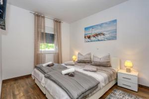 ein Schlafzimmer mit einem großen Bett und einem Fenster in der Unterkunft Apartments Laguna in Nin