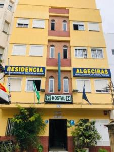 un edificio amarillo con una señal para un hospital en HOSTAL ALGECIRAs en Algeciras