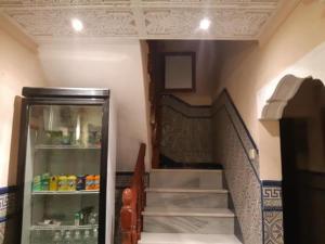 Una escalera en una habitación con nevera al lado de una escalera en HOSTAL ALGECIRAs, en Algeciras