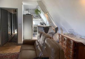 sala de estar con sofá y cocina en La Visitation - 30 en Orthez