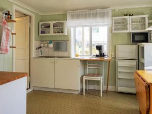 斯莫庚的住宿－4 person holiday home in Sm gen，厨房配有白色橱柜、桌子和窗户。