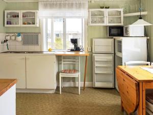斯莫庚的住宿－4 person holiday home in Sm gen，厨房配有白色冰箱和桌椅