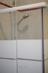 puerta de ducha de cristal con cabezal de ducha en el baño en CASA VACANZE GLI ULIVI DEL LAGO, en Sale Marasino