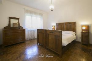 1 dormitorio con cama, tocador y espejo en CASA VACANZE GLI ULIVI DEL LAGO, en Sale Marasino