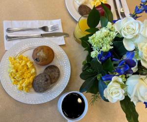 a table with plates of food and a vase of flowers at The Cook Hotel & Conference Center in Baton Rouge