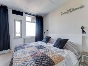 een slaapkamer met een groot bed en blauwe gordijnen bij Beautiful apartment in city center in Leeuwarden