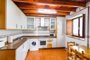 cocina con electrodomésticos blancos y suelo de madera en Cómoda casa en entorno natural y cerca de la playa, en Somo