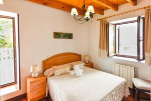 - une chambre avec un lit et 2 fenêtres dans l'établissement Cómoda casa en entorno natural y cerca de la playa, à Somo