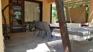 patio con mesa, sillas y porche en Casa la Petcu, en Costinesti