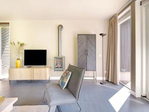 a living room with a television and a chair at Spacious and stylish family home in Grou in Grou