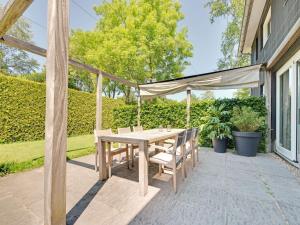 Une table et des chaises en bois sont disponibles sur la terrasse. dans l'établissement Spacious and stylish family home in Grou, à Grou