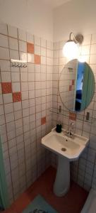 ein Bad mit einem Waschbecken und einem Spiegel in der Unterkunft Paperboat apartment in Afytos