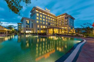 a hotel with a pool in front of it at Muong Thanh Holiday Quang Binh Hotel in Dong Hoi