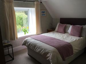 Un dormitorio con una cama grande y una ventana en Borthalan House en Carbis Bay