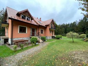 a house with a bench in a yard at Miodowa Polana in Polańczyk