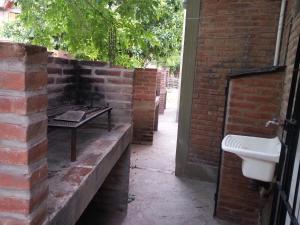 eine Backsteinwand mit einem Waschbecken und einem Tisch in der Unterkunft Cabañas Soleado Villa Cura Brochero in Villa Cura Brochero