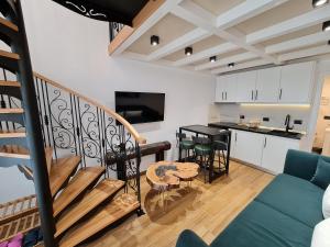 a living room with a staircase and a kitchen at Bujtina Gjyshi Ilo in Pogradec