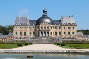 um grande edifício com um barco na água em frente em Studio Dreams Paris em Montévrain