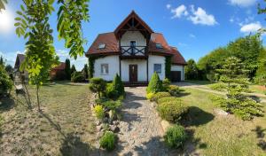 a white house with a red roof at Willa Julianna in Mikołajki