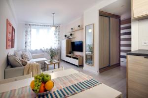 a living room with a couch and a table with fruit on it at W&K Apartments - Compact II in Koszalin
