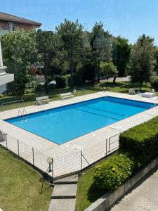 ein großes Schwimmbecken mit einem weißen Zaun darum herum in der Unterkunft Esperia 1 Piscina e Parcheggio in Caorle