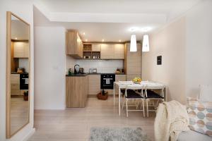 a kitchen and dining room with a table in a room at Compact II - Mieszkanie na parterze, Faktura VAT, szybkie Wi-Fi, Netflix in Koszalin