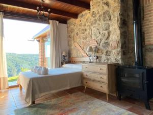 ein Schlafzimmer mit einem Bett und einer Steinwand in der Unterkunft Olivar de Gredos in Arenas de San Pedro + 42 Fotos
