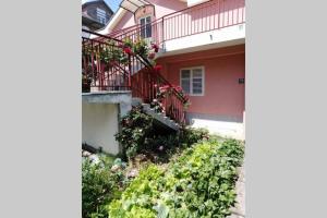 a house with a balcony with flowers on it at Apartman Danica in Herceg-Novi