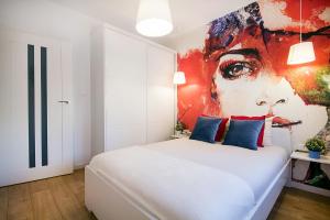 um quarto com uma cama branca e uma pintura na parede em W&K Apartments - Blue Suite em Koszalin