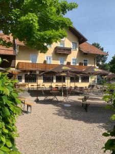 a building with tables and umbrellas in front of it at Gasthof Löwen in Pfronten