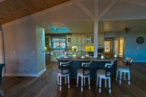 una cocina abierta con una gran isla con taburetes de bar en Cozy mountain retreat with lake views near Yosemite, en Groveland