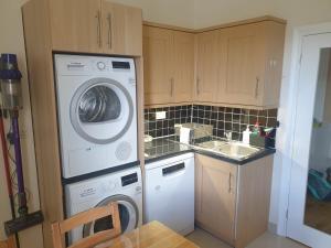 a kitchen with a washing machine and a sink at London Luxury 2 Bedroom Flat 5min walk from Overground, with FREE WIFI, FREE PARKING-Sleeps x6 in Ilford +26 photos