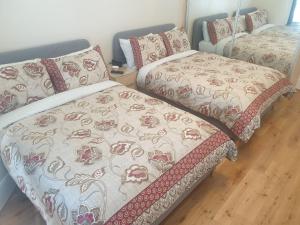 two beds sitting next to each other in a room at London Luxury 2 Bedroom Flat 5min walk from Overground, with FREE WIFI, FREE PARKING-Sleeps x6 in Ilford