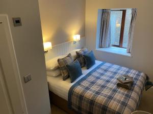 una camera da letto con letto, cuscini e finestra di Adrian's Guest House a Inverness