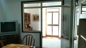 een kamer met een tafel, een spiegel en een televisie bij Mare&Monti II in Telti