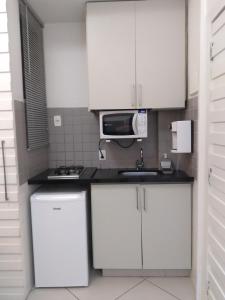 cocina blanca con fregadero y microondas en Studios Atlantica Prime, en Río de Janeiro