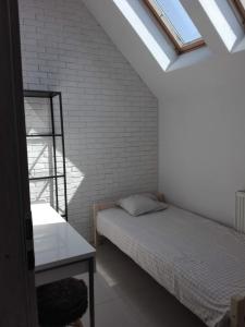 - une chambre avec un lit et un mur en briques dans l'établissement Przytulny loft 5 min od centrum Gdańska, à Gdańsk