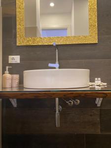 a bathroom with a white sink and a mirror at B&B Libertà in Pachino