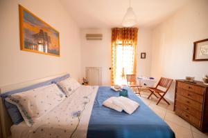 1 dormitorio con 1 cama azul y 2 toallas en ANFOL, en Bari