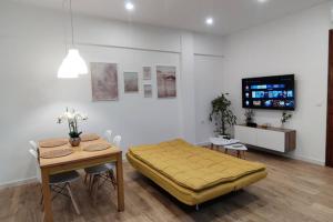 Cette chambre comprend un lit, une table et une télévision. dans l'établissement Xátiva Home, Loft Center, à Xàtiva