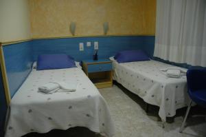 2 camas en una habitación con paredes azules en Hostal El Cartero en Teruel