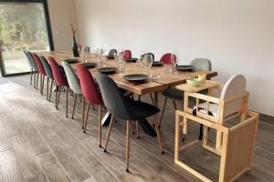 una larga mesa de madera y sillas en una habitación en Gîte campagne famille 15 pers Piscine chauffée Jeux enfants Pétanque en Saint-Sauvy