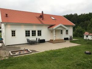 uma casa branca com um telhado laranja e um quintal em Videvägen 20 Strömstad em Strömstad