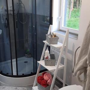 a bathroom with a shower and a ladder with baskets at Klimatyczny domek blisko natury na Podlasiu - Wysokie Laski 9! in Sokółka