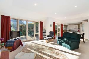 ein Wohnzimmer mit einem grünen Sofa und einem TV in der Unterkunft Casa Bella - Nelson Holiday Home in Nelson